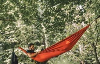 Man in hammock reads adventure book